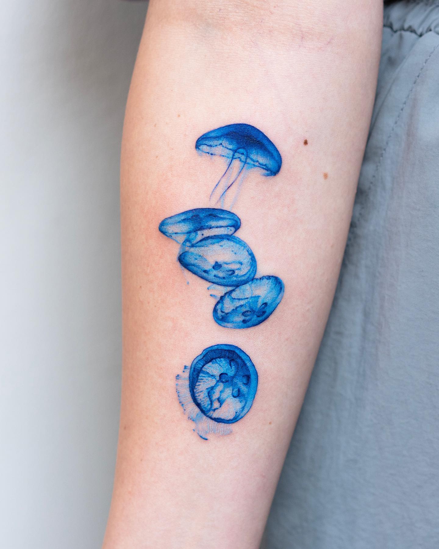 Tatuaje de medusa azul, tinta pequeña.