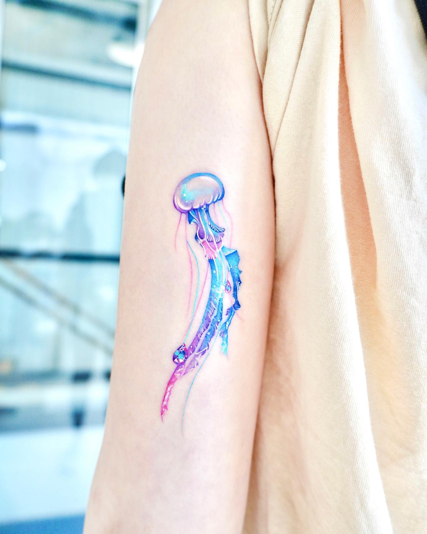Tatuaje de medusa azul en el brazo.