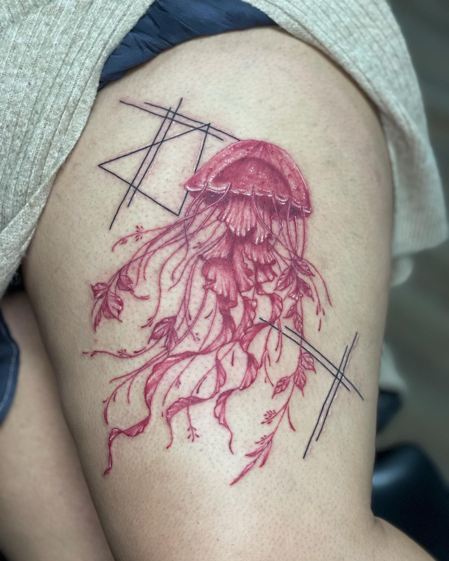 Tatuaje de medusa fresca en el muslo