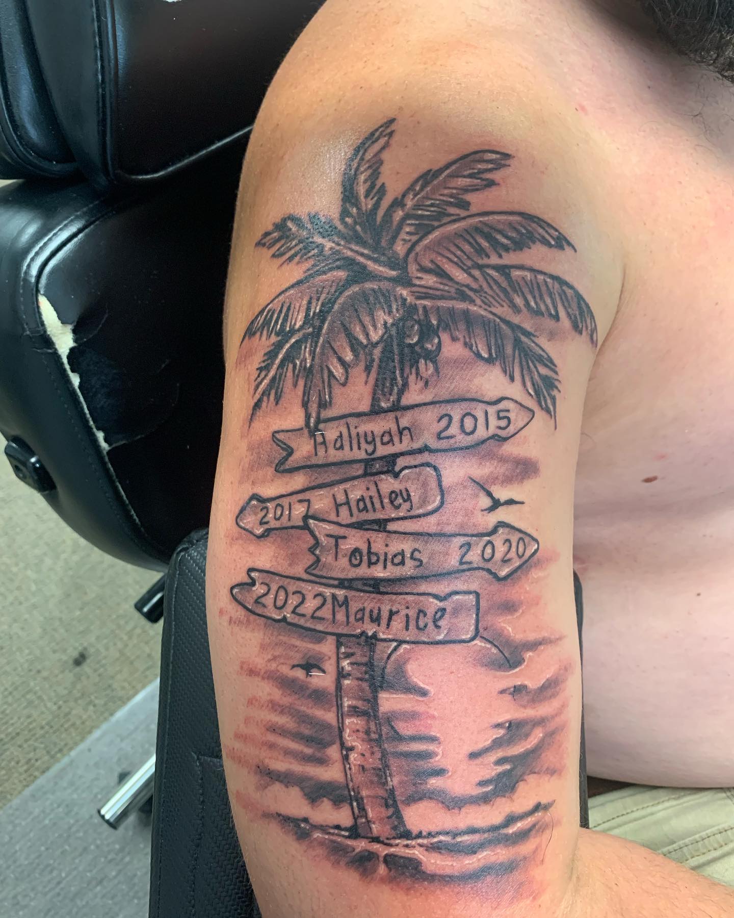 Tatuaje de palmera con letreros