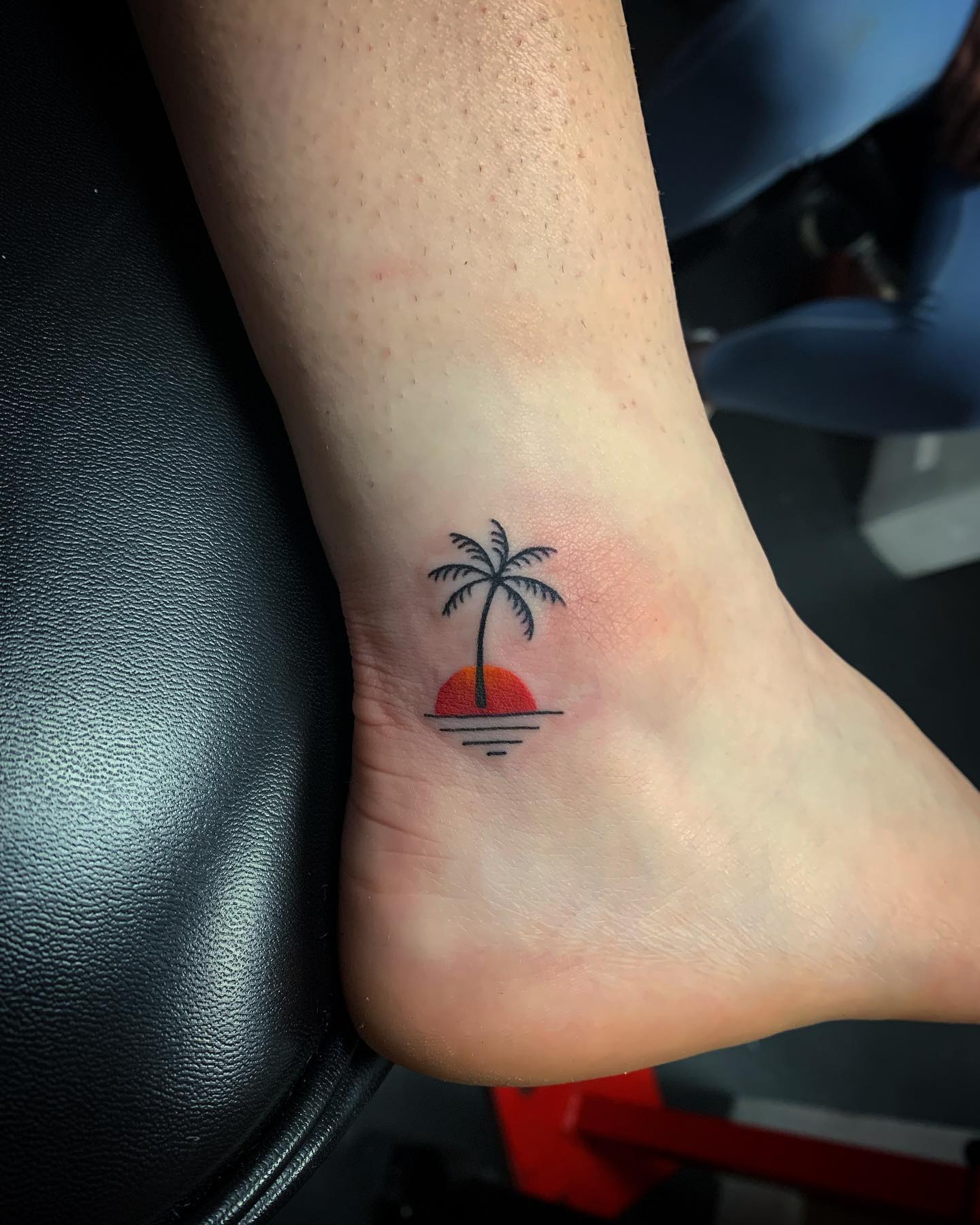 Tatuaje de palmera pequeña en el tobillo.