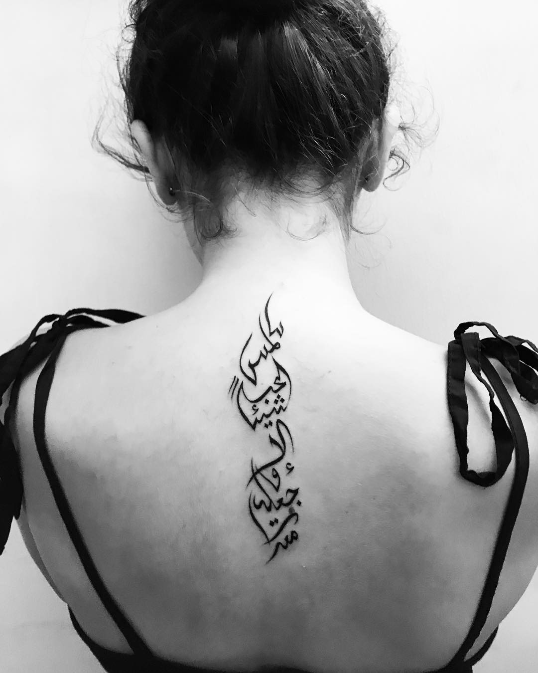 Tatuaje árabe en la espalda.