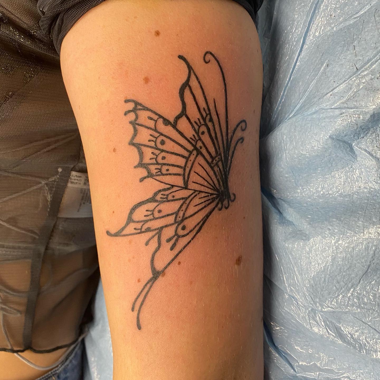 Tatuaje de contorno de mariposa negra.