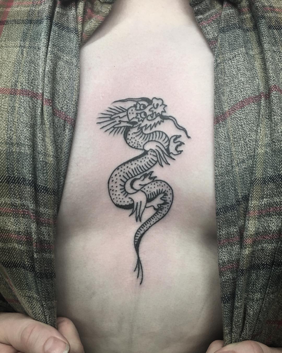 Tatuaje de esternón de pequeño dragón.