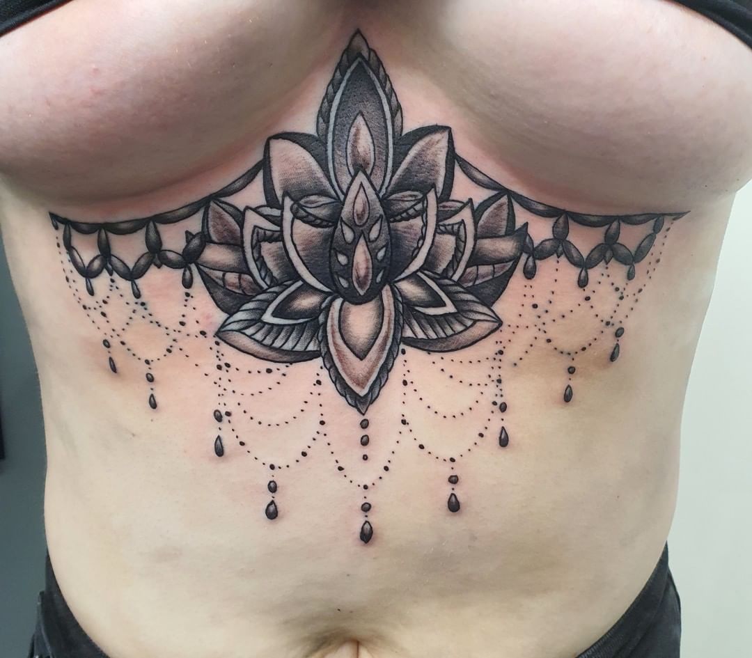 Tatuaje de mandala entre los senos.