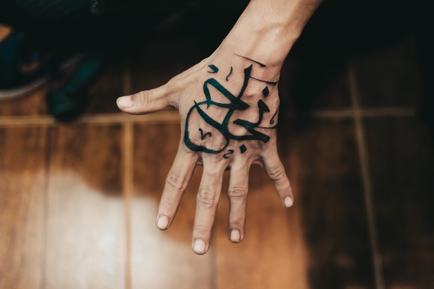 Tatuaje de mano en árabe