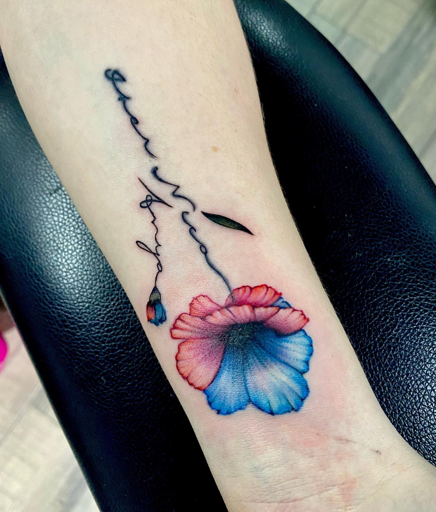 Tatuaje tradicional americano de flores rojas y azules.