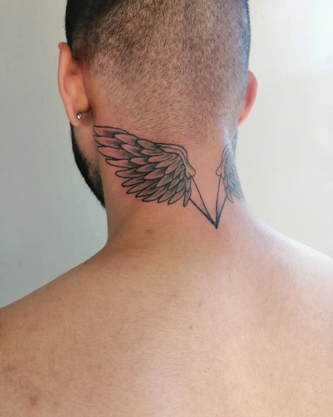 Tatuajes de alas en el cuello.