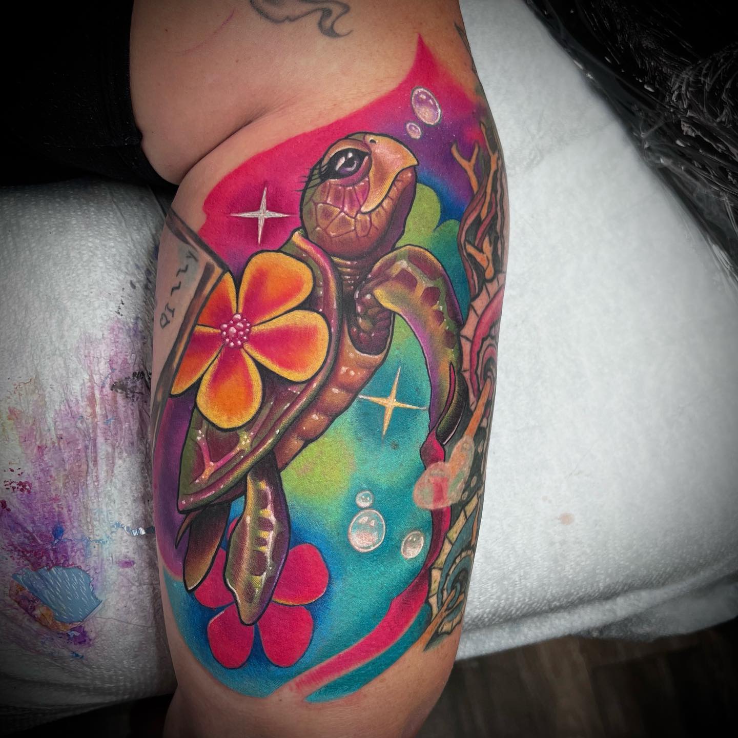 Lindo tatuaje de tortuga marina con flores.