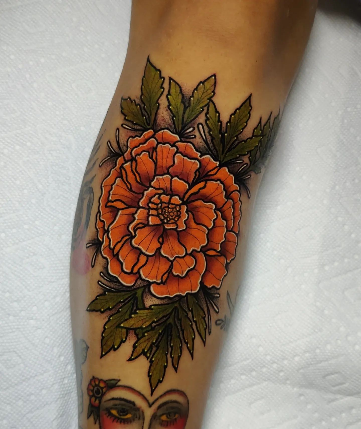 Tatuaje de caléndula, tinta naranja.