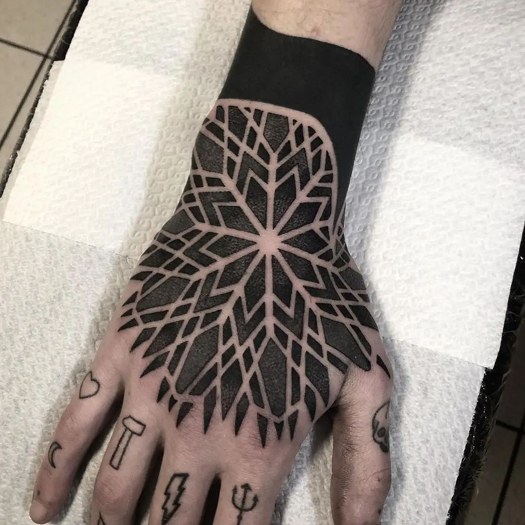 Tatuaje de mano con mandala y tinta negra para hombres.