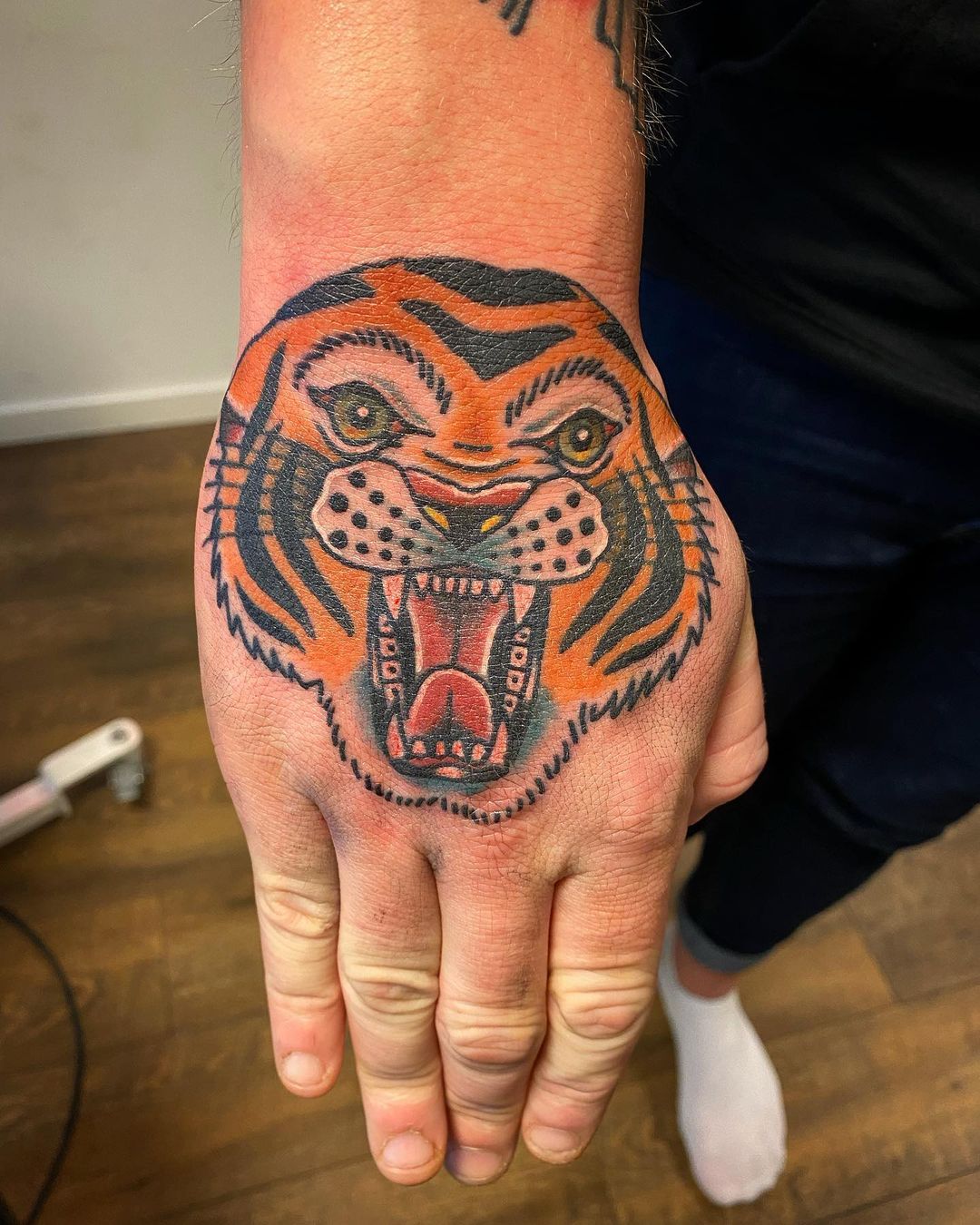 Tatuaje de mano de tigre naranja para hombres.