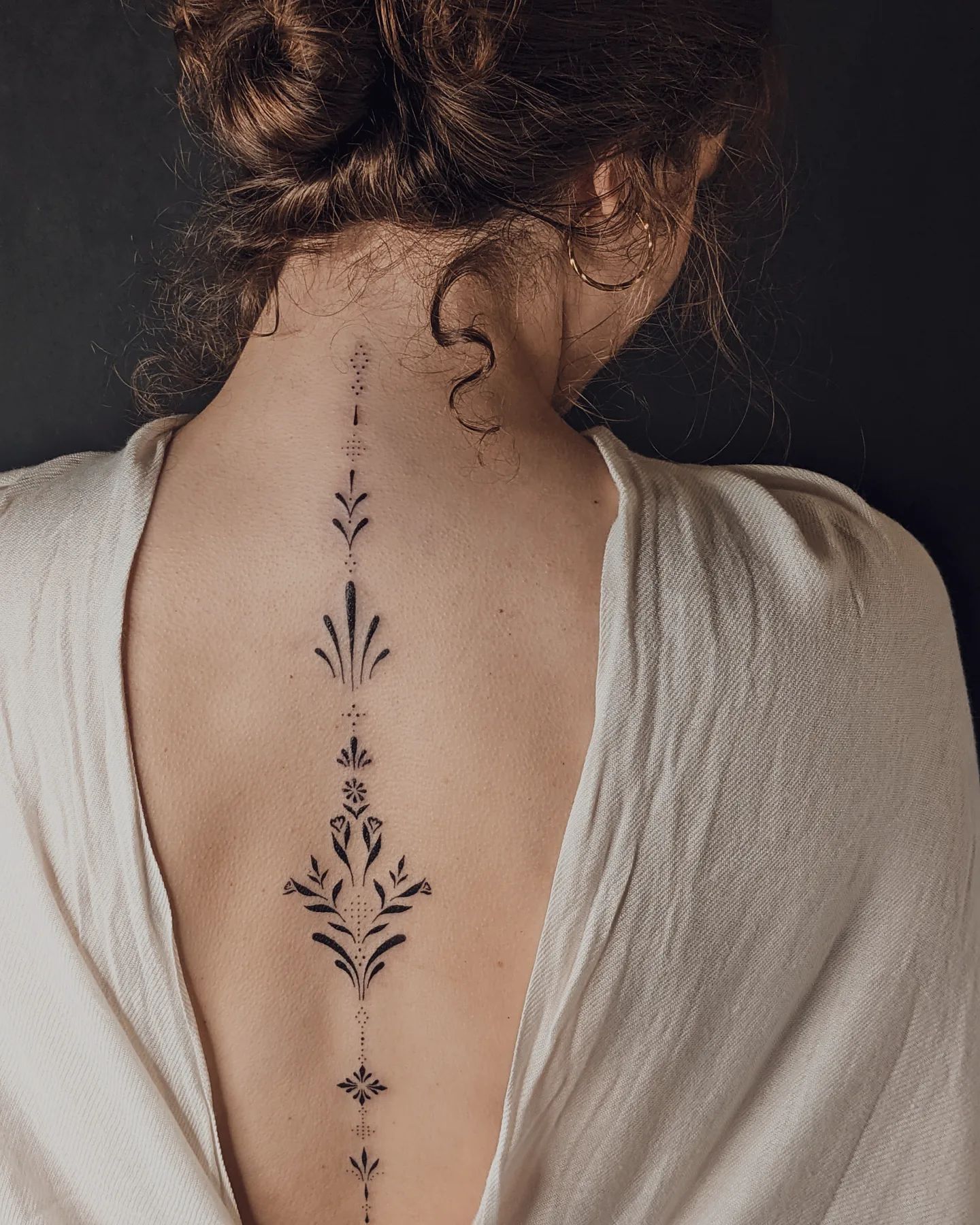 Tatuaje pequeño y minimalista en la columna vertebral