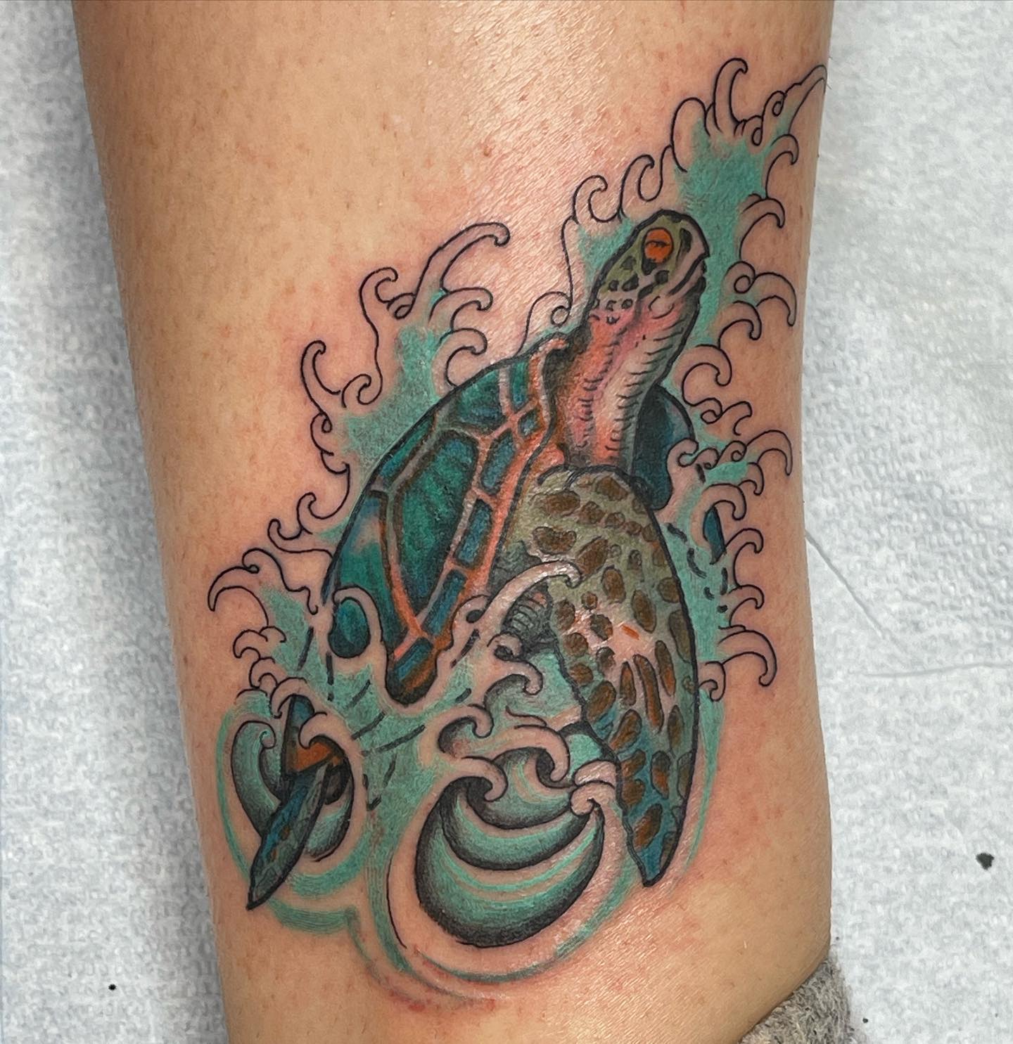 Tortuga marina con tatuaje de olas del mar.