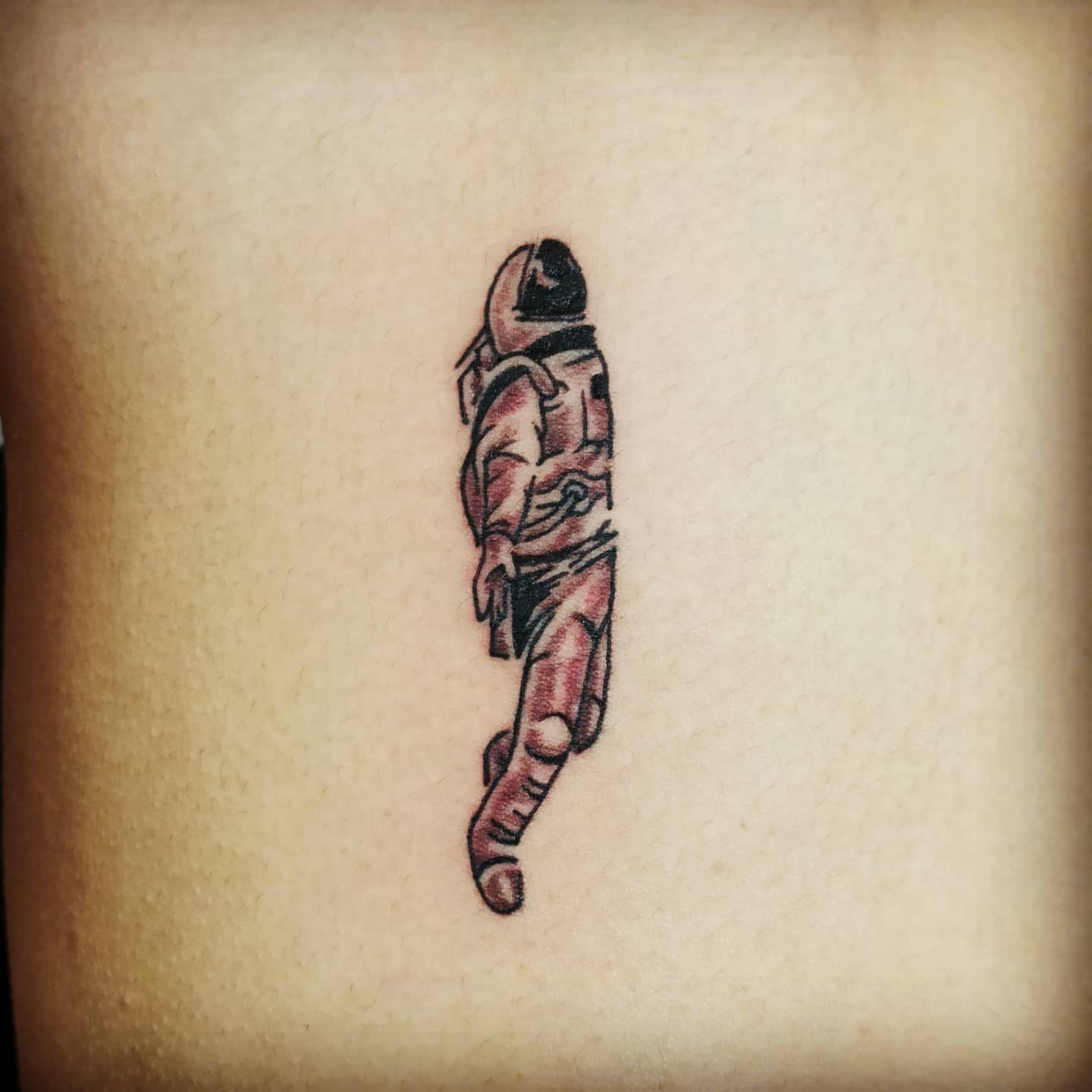 Pequeño tatuaje de astronauta para hombres.