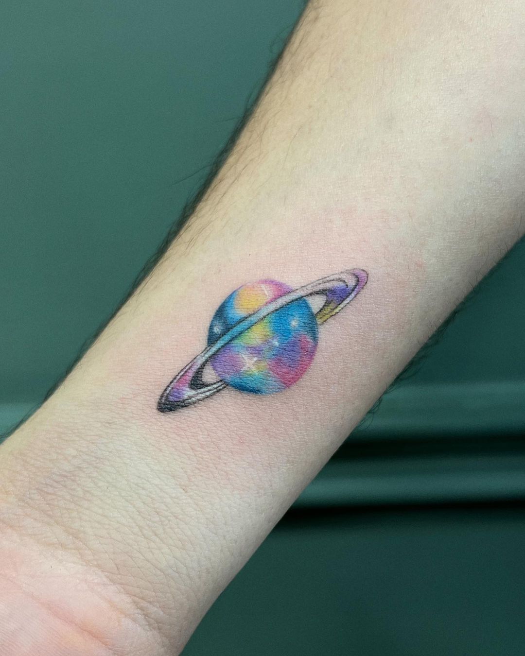 Pequeño tatuaje de Saturno para hombres.