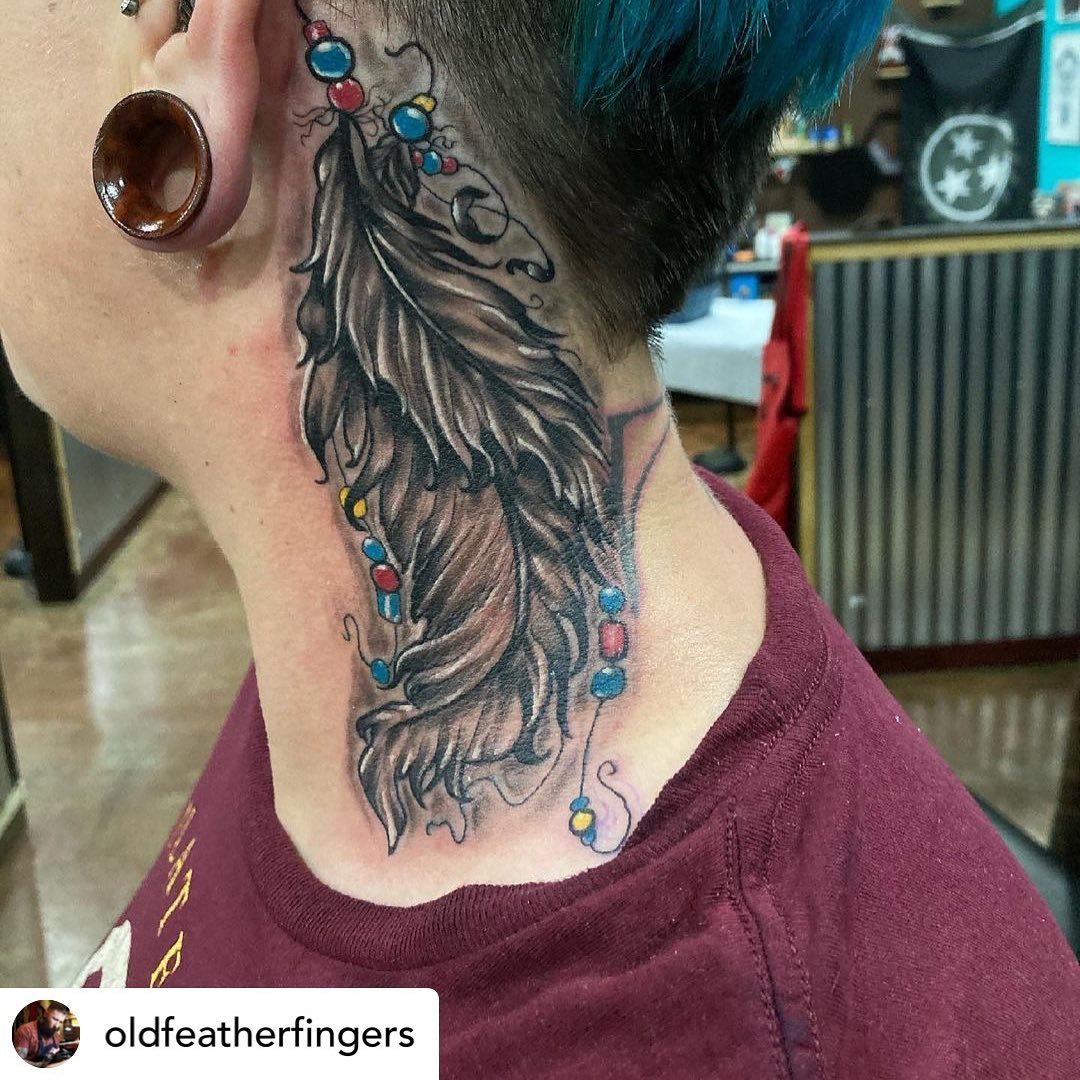 Tatuaje de pluma en el cuello para mujeres.