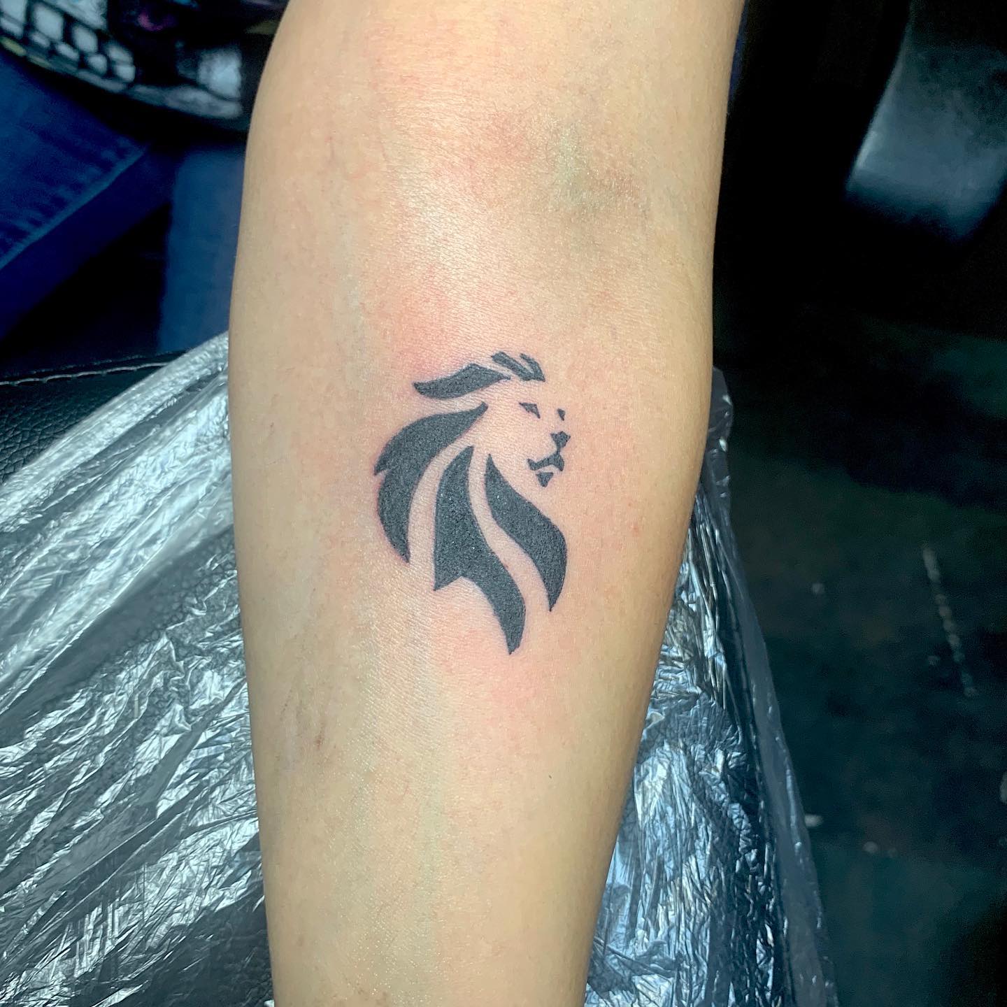 Tatuaje pequeño de león para hombres.