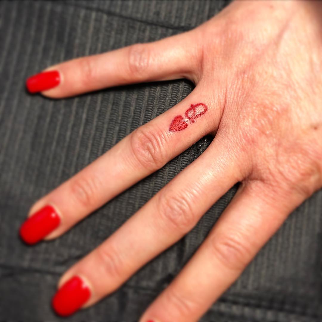 Tatuaje de reina de espadas en el dedo.