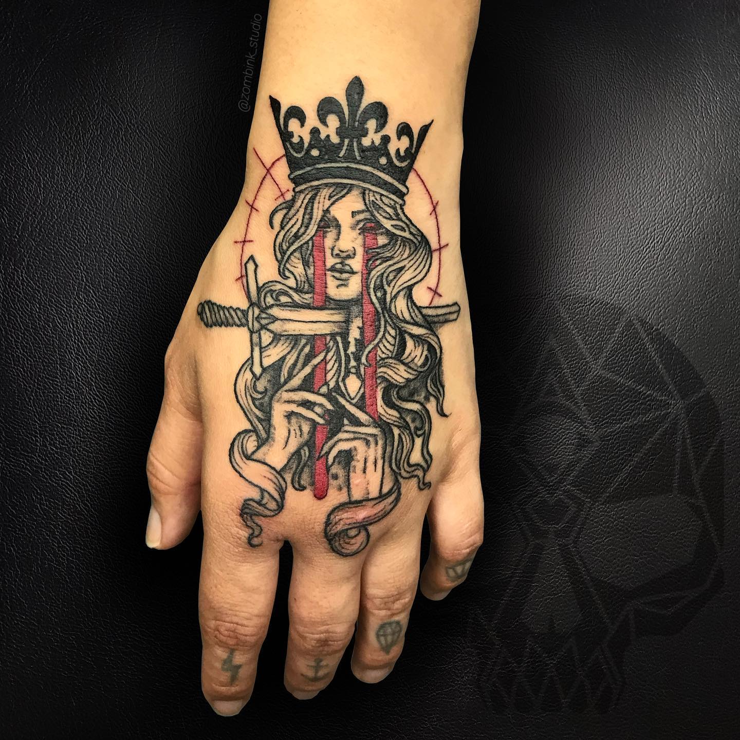 Tatuaje de Reina de Espadas en la mano.
