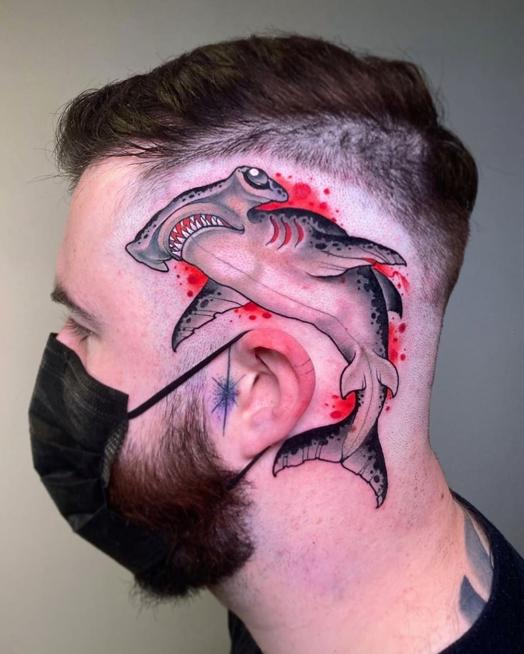 Tatuaje de tiburón negro y rojo aterrador.