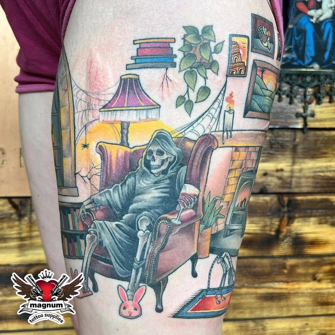 El segador de la Muerte en el muslo tatuado en casa.