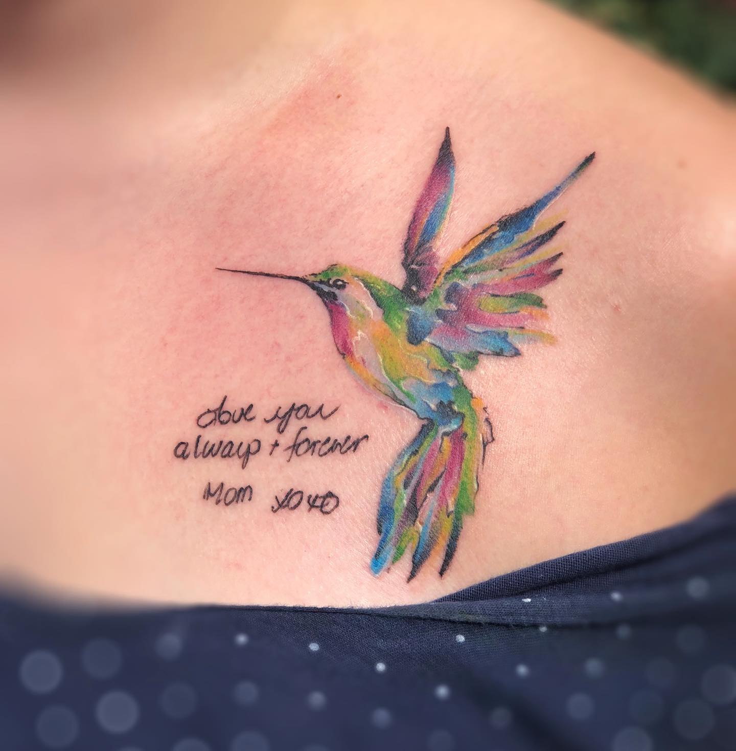 Tatuaje de clavícula de ave colorida.