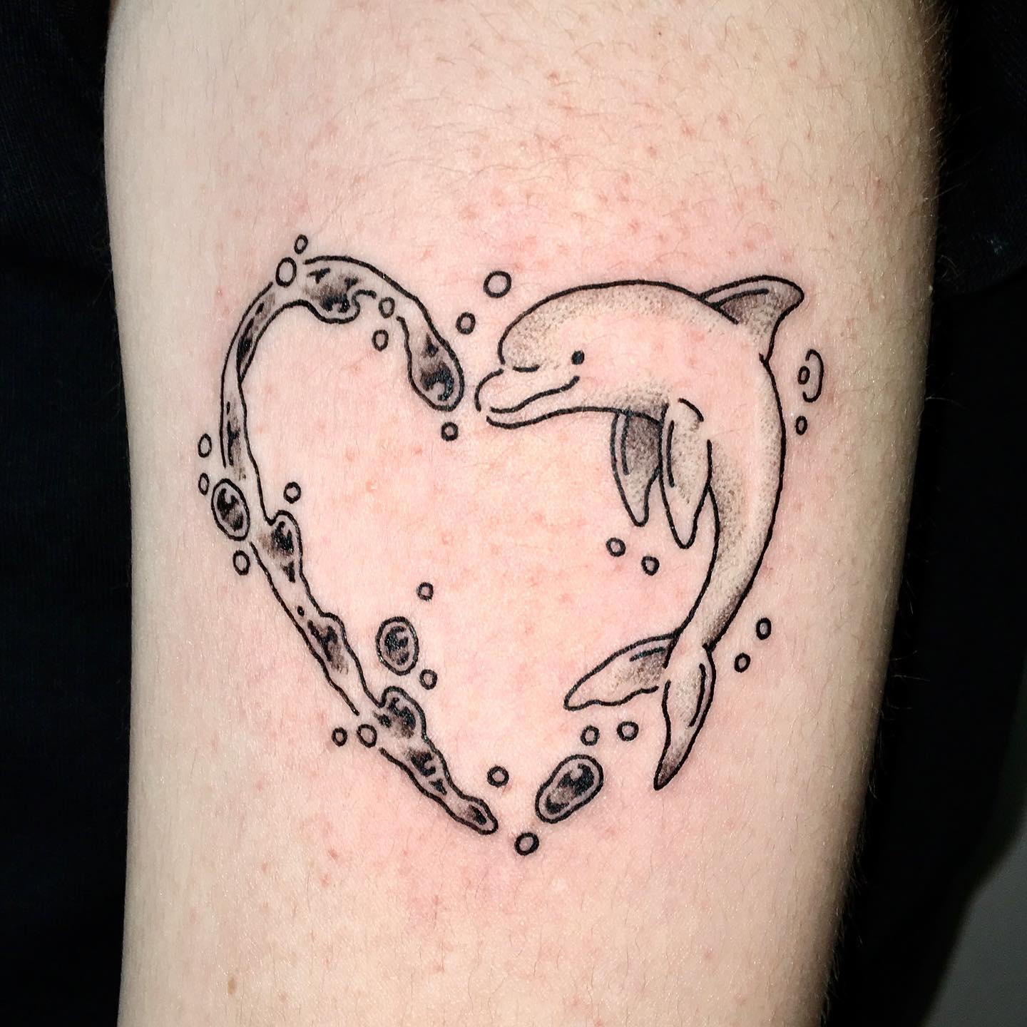 Tatuaje de corazón y delfín.