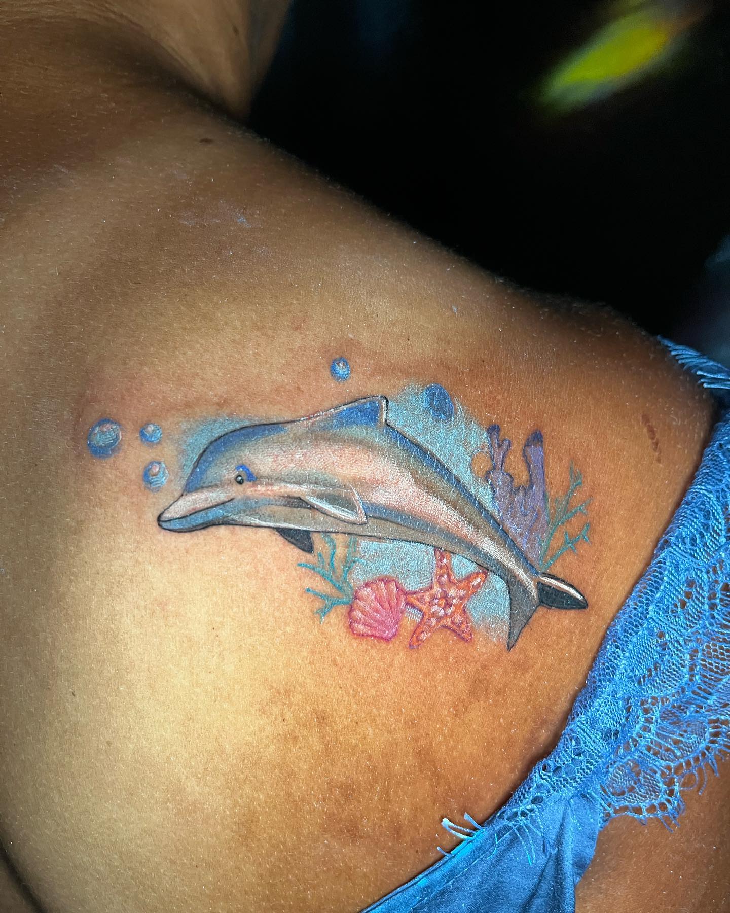 Tatuaje de delfín azul en la espalda