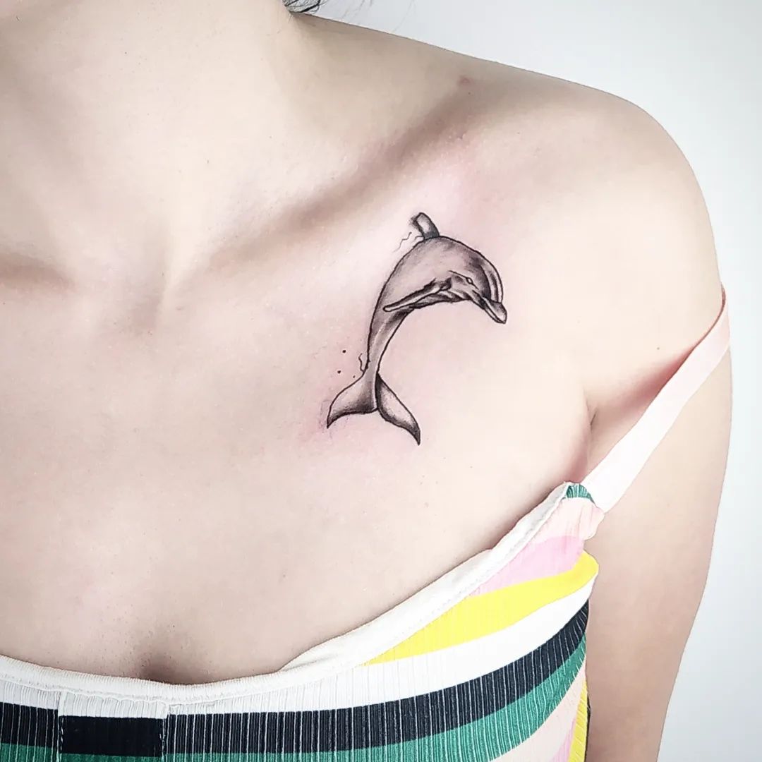 Tatuaje de delfín en la clavícula