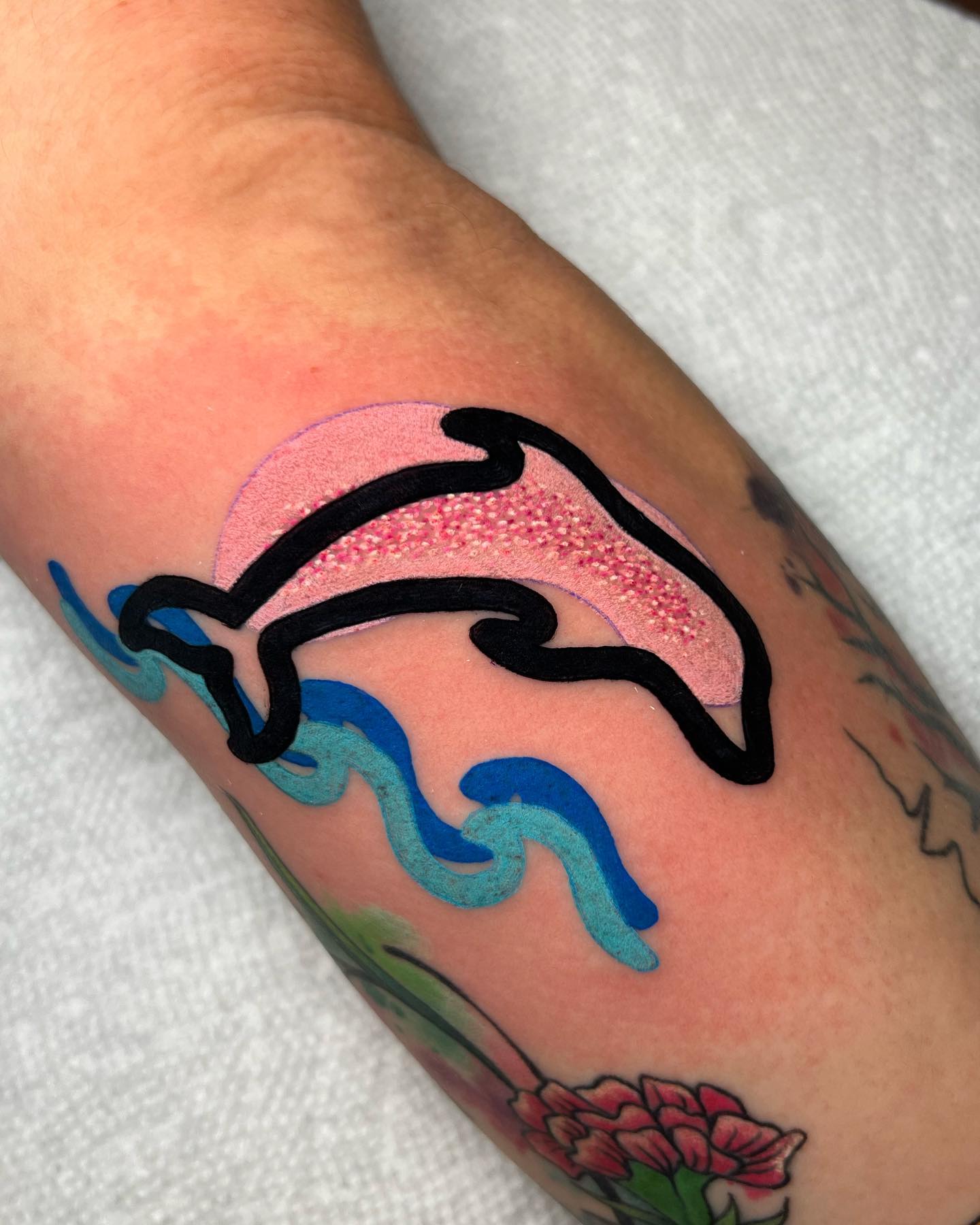 Tatuaje de delfín vibrante y divertido.