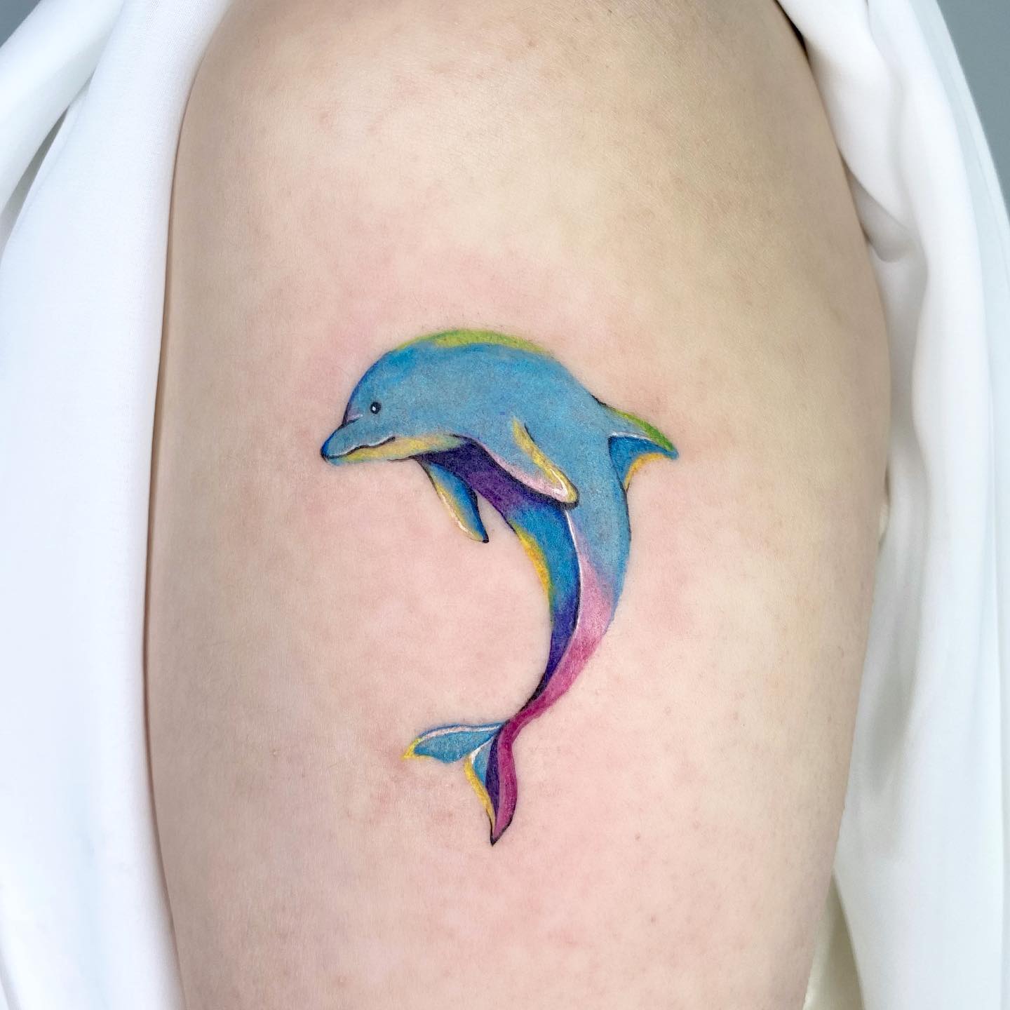 Tatuaje de delfines vibrante y fresco.