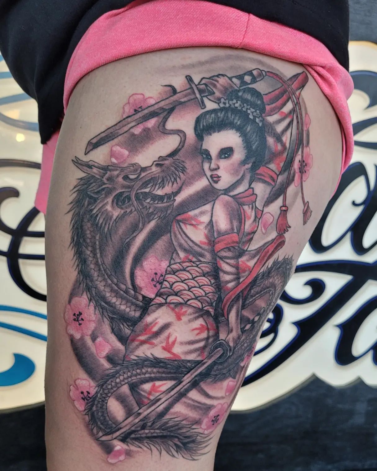 Tatuaje de guerrera femenina asiática en el muslo.