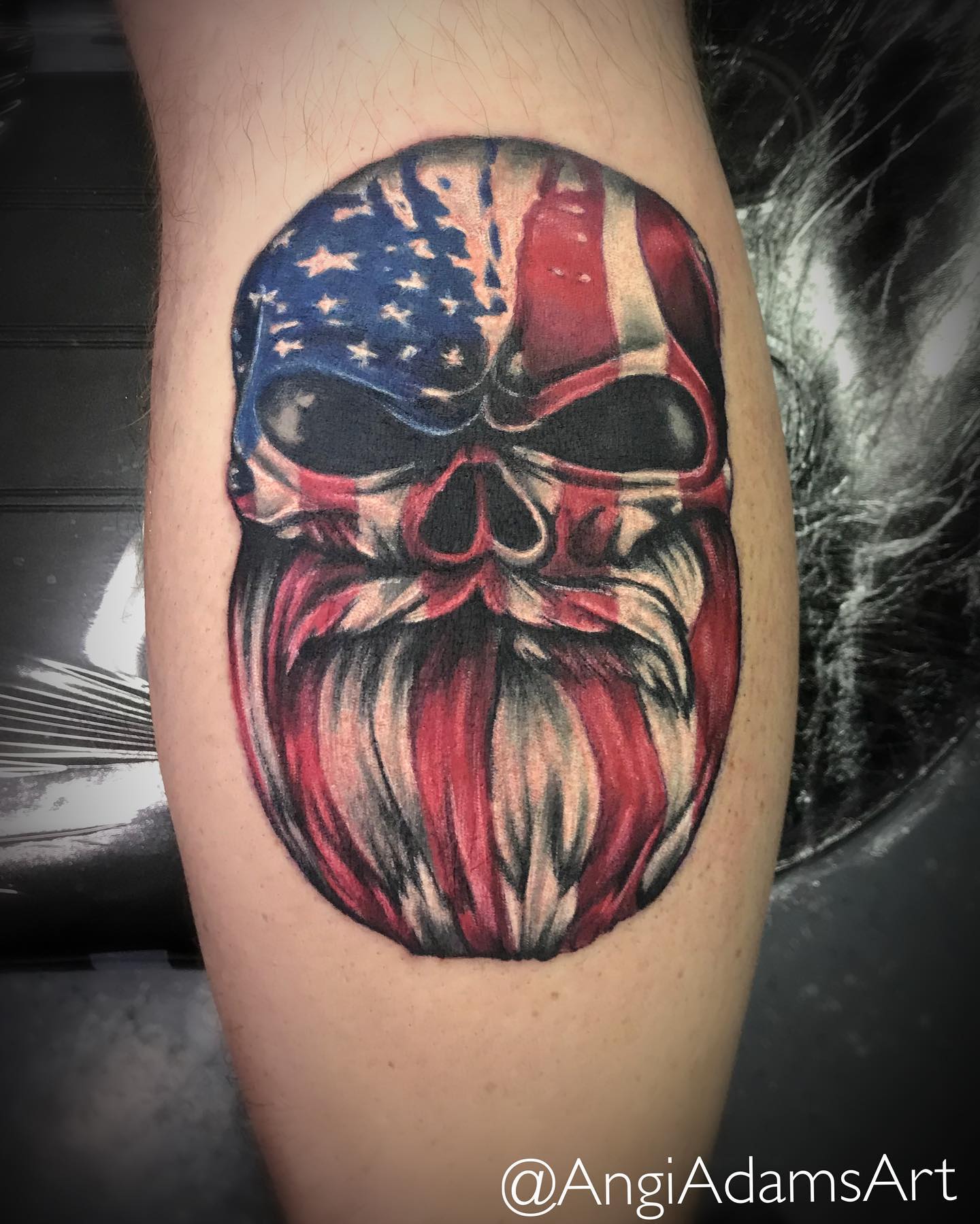 Tatuaje de calavera y bandera estadounidense en la pantorrilla.