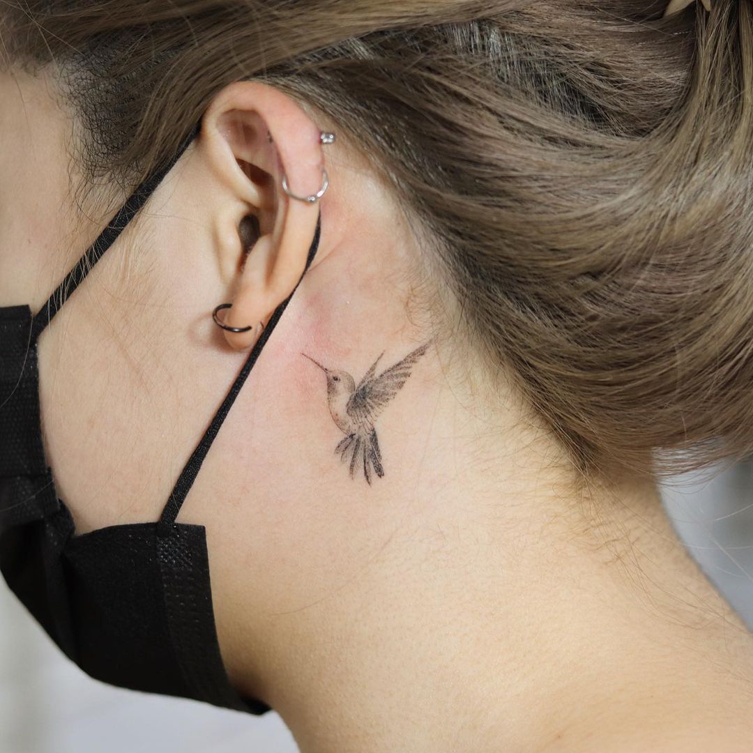 Tatuaje de colibrí con cuello de tinta negra.