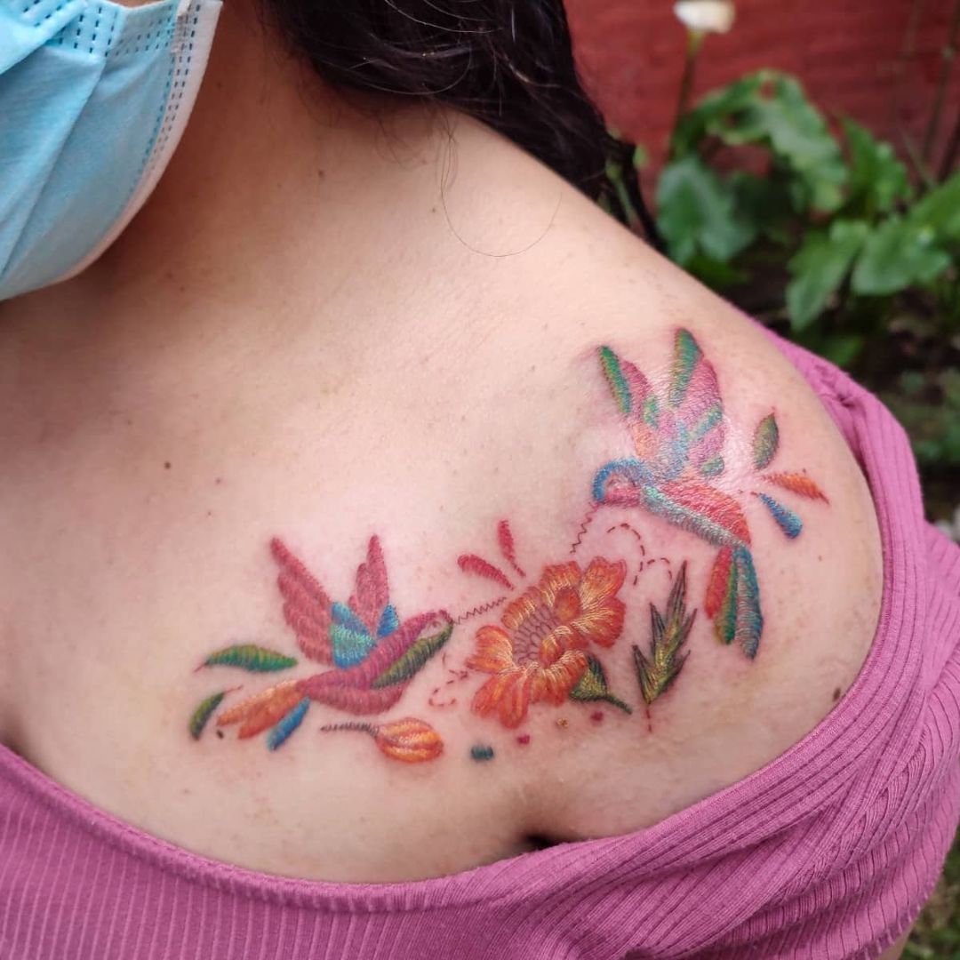 Tatuaje de colibrí en el cofre y la clavícula.