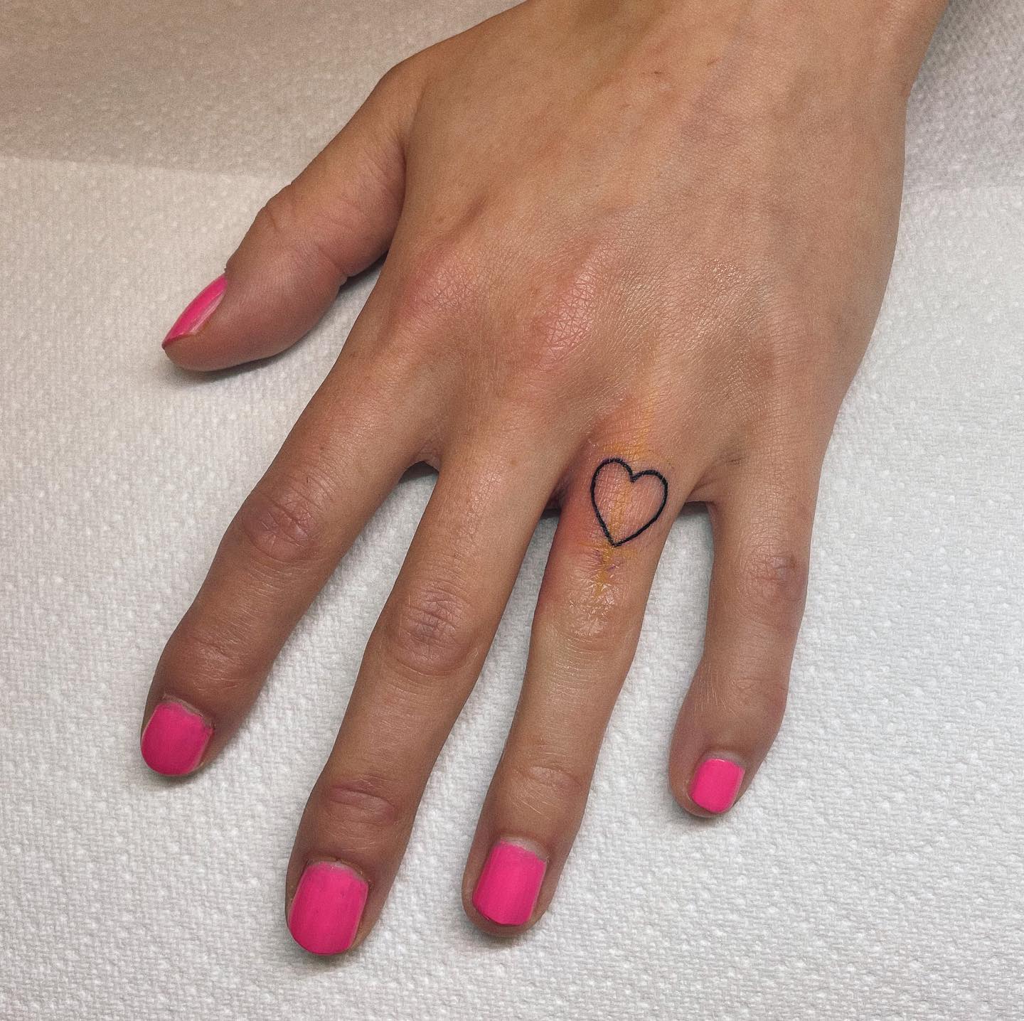 Tatuaje de símbolo de corazón en el dedo