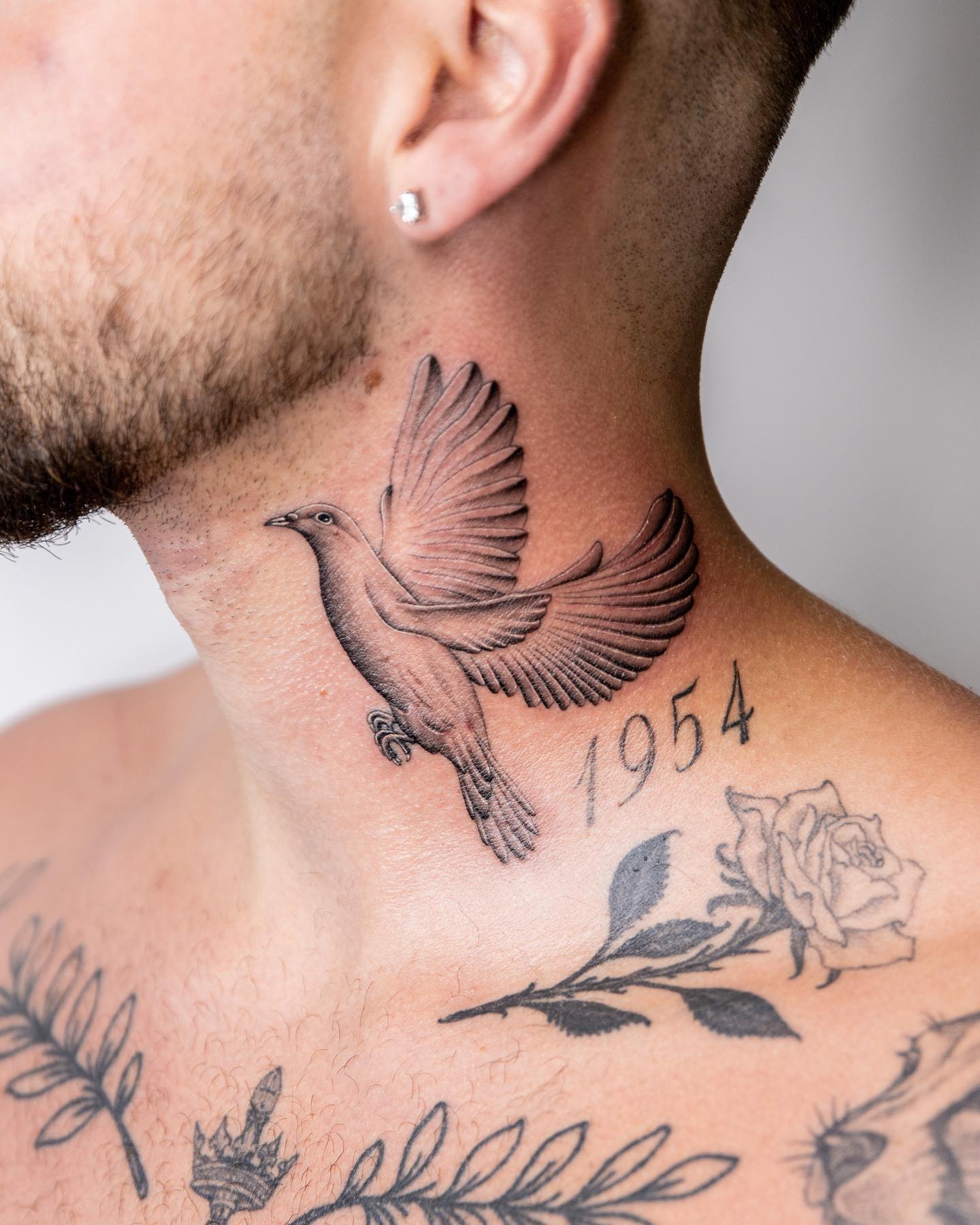 Tatuaje de una paloma en el cuello para hombres.