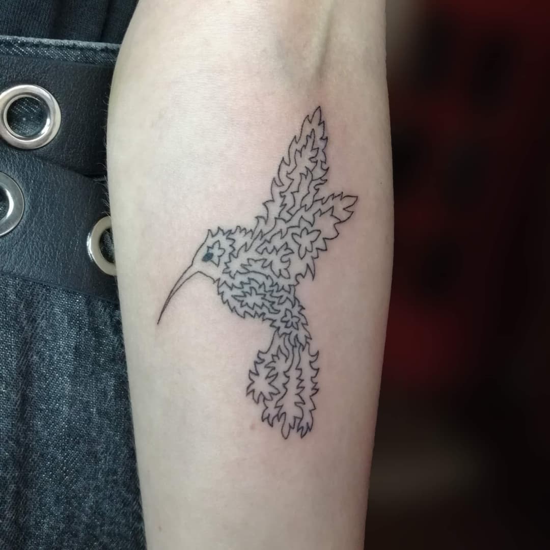Tatuaje detallado de colibrí con tinta negra.