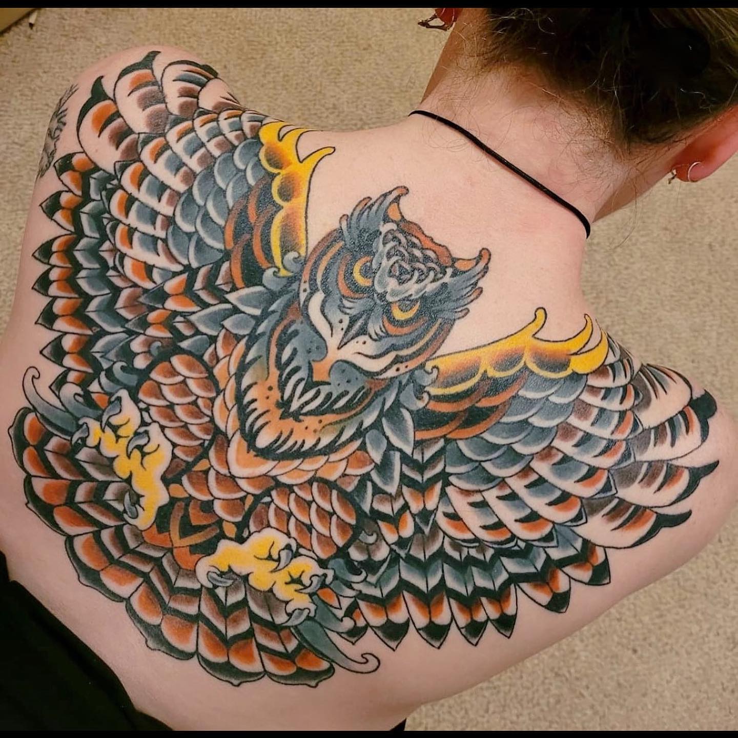 Gran tatuaje de búho en la espalda.