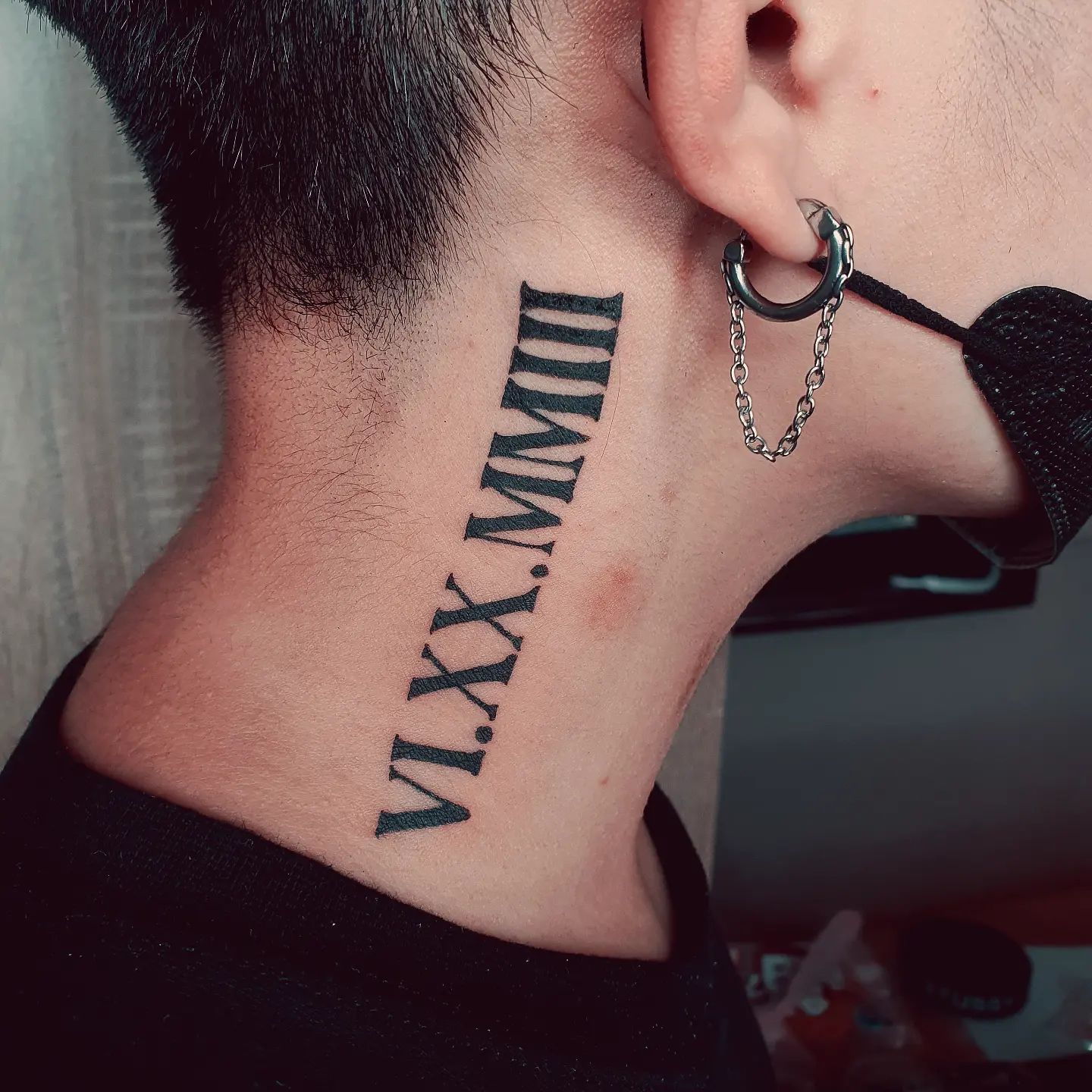Gran tatuaje de números romanos en el cuello