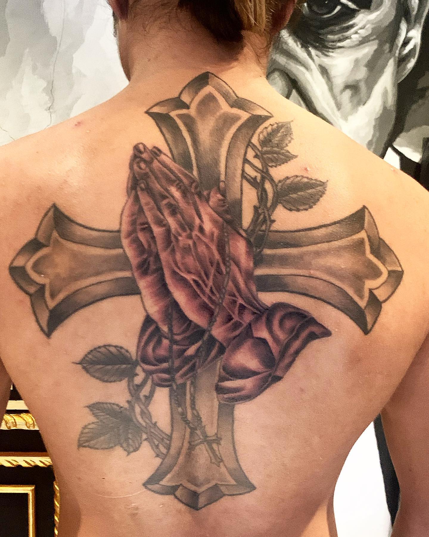 Tatuaje de Manos Orando en la Espalda