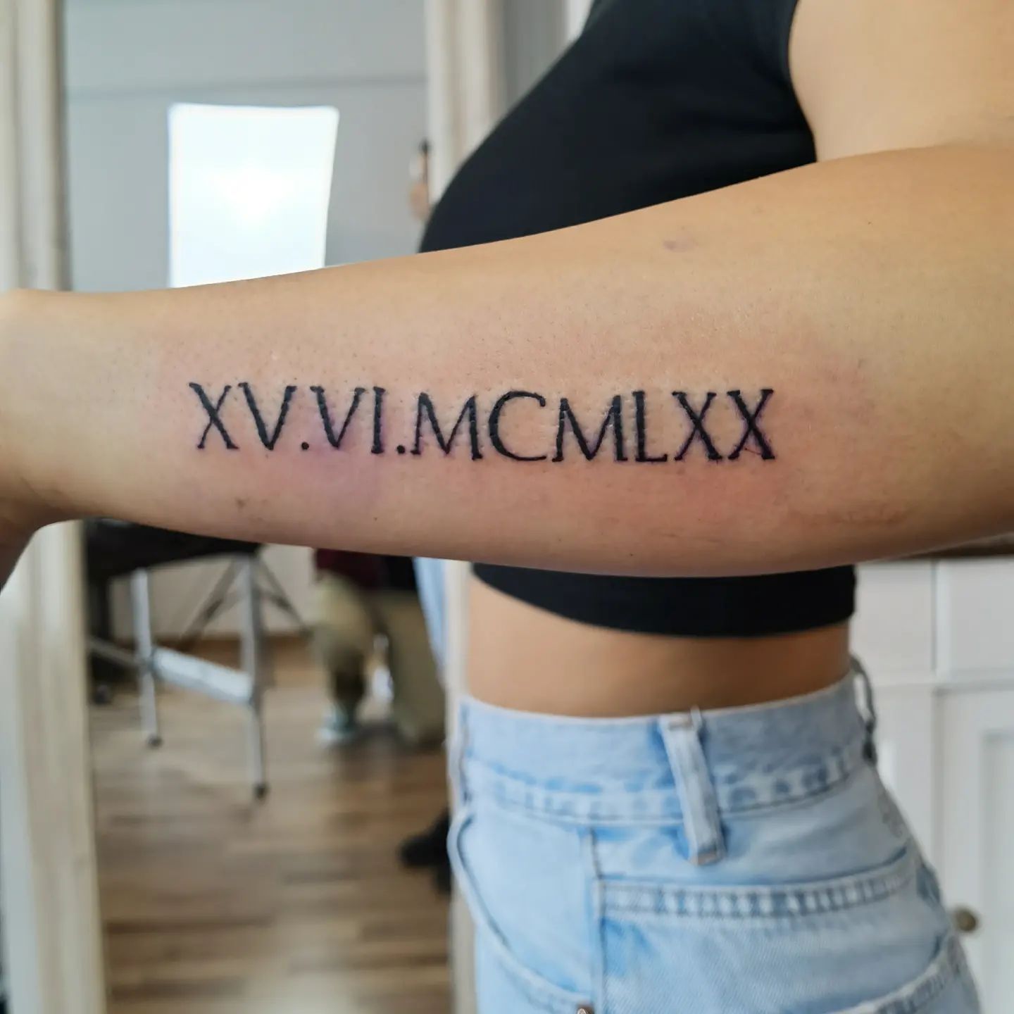 Tatuaje de número romano en el brazo