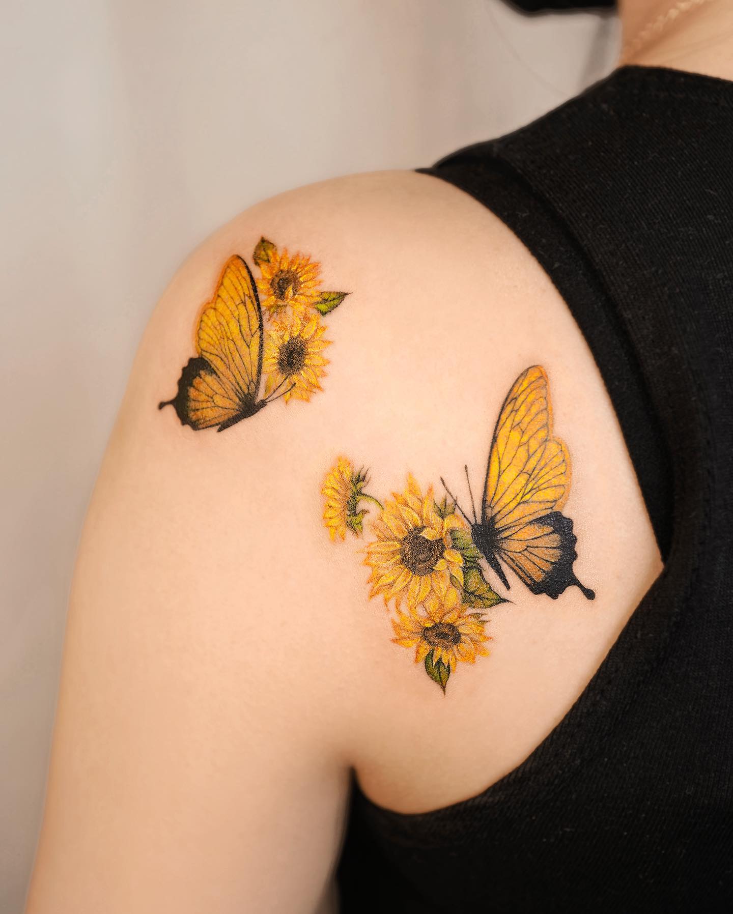 Tatuaje de girasol y mariposa