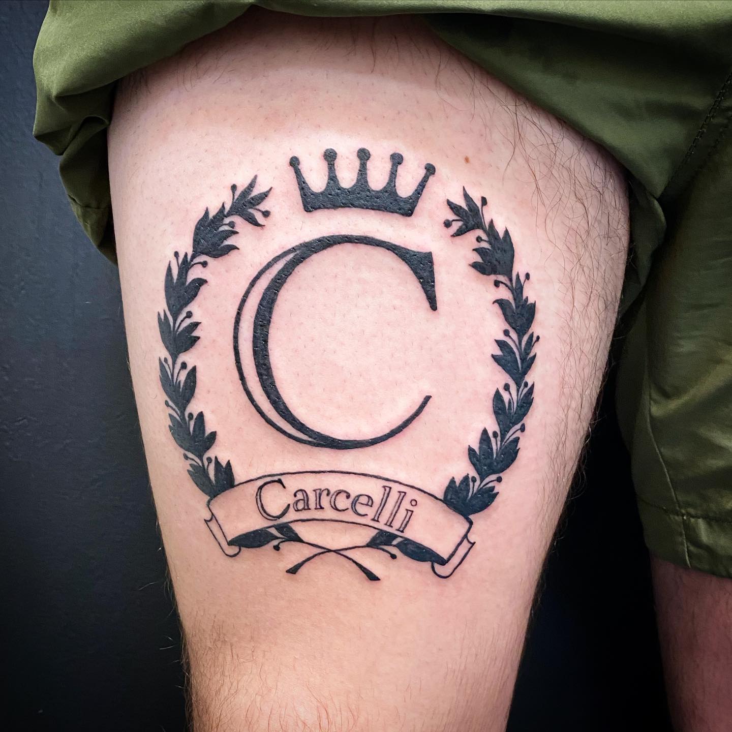 Tatuaje del escudo familiar en el muslo