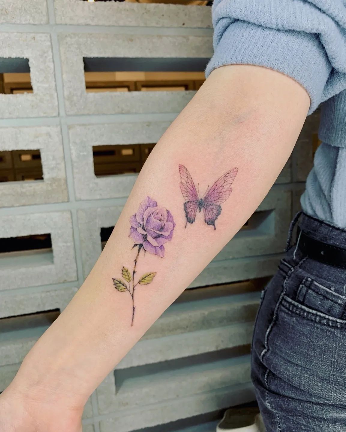 Mariposa púrpura y tatuaje de rosa