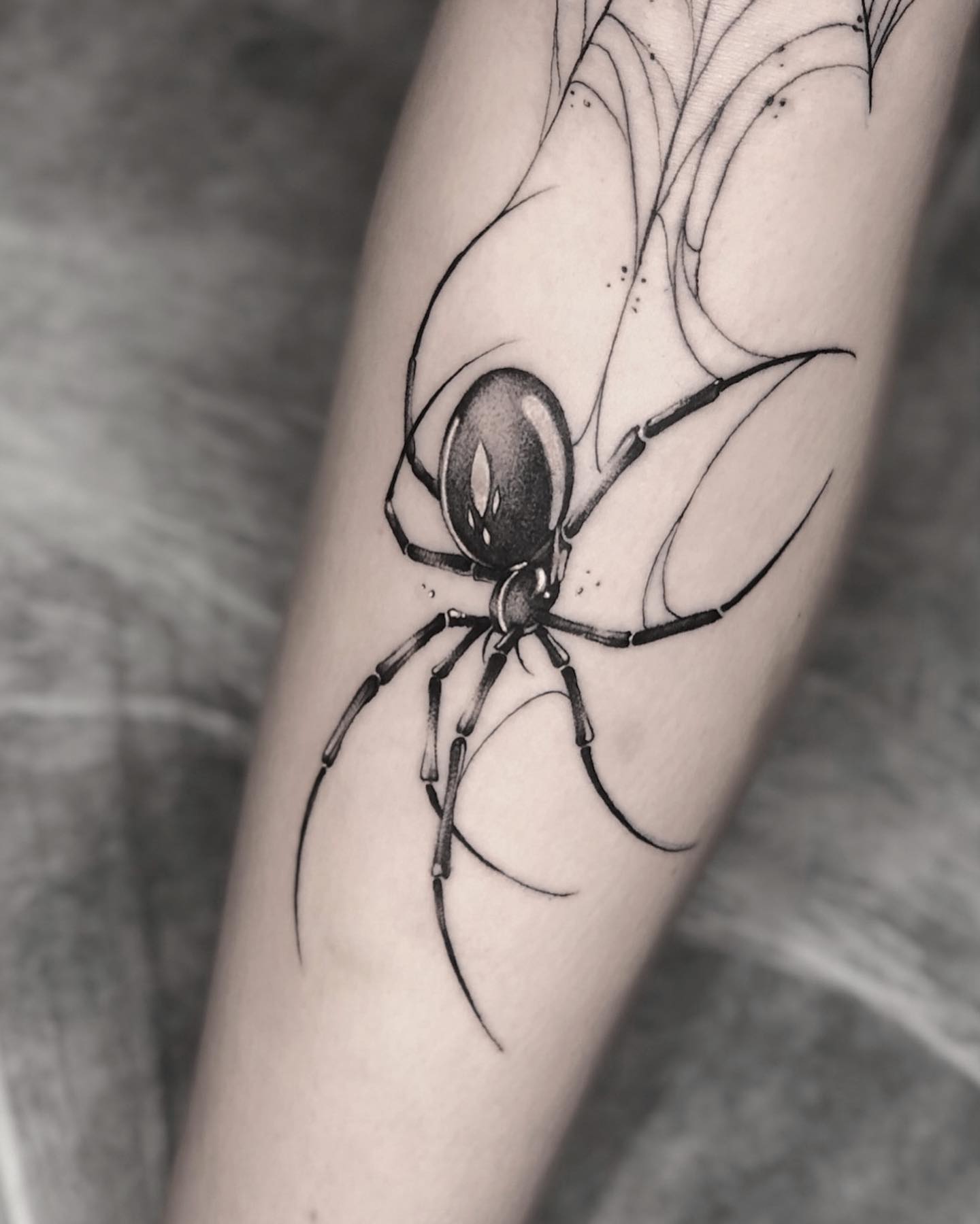 Tatuaje de araña y tela de araña con tinta negra.