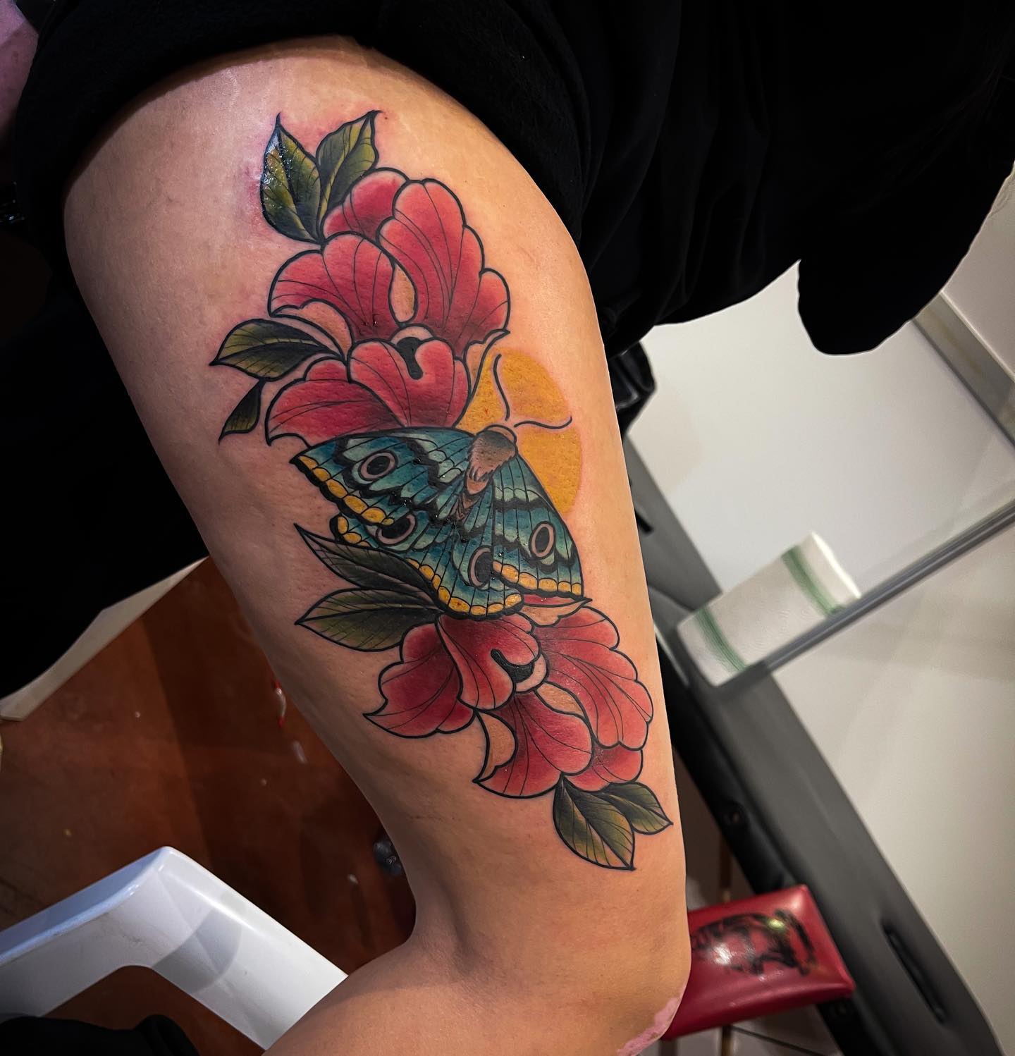 Tatuaje de mariposa con flores.
