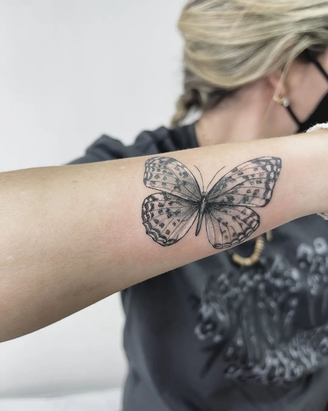 Tatuaje de mariposa en el antebrazo.