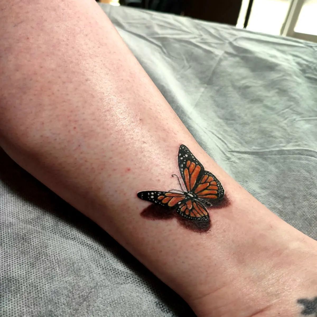 Tatuaje de mariposa naranja.